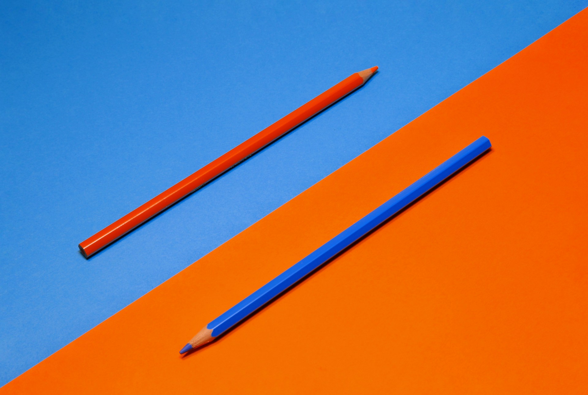 Zwei Buntstifte auf farblichem Kontrast als Sinnbild für einen Perspektivenwechsel
